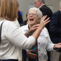 Woman laughing while in conversation with other event attendee